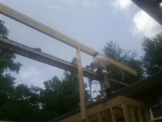 Carpenter setting a ridge beam over a new addition frame — Ice Dam Removal by Roofing Brothers in Banner Elk