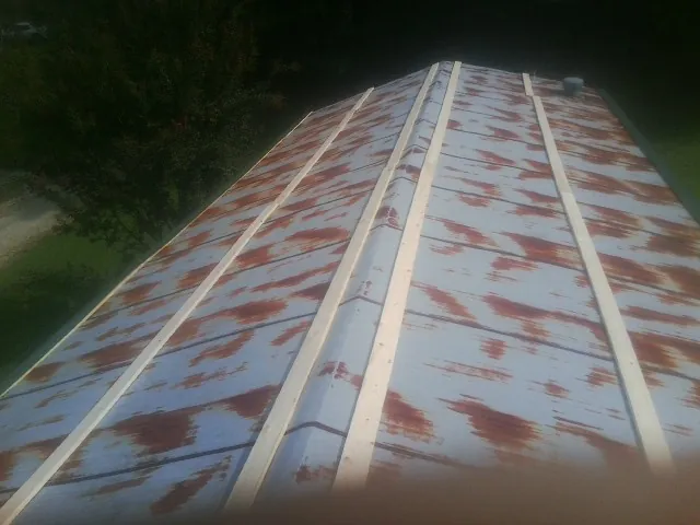 Rusted metal roof panels with new wood purlins before replacement — Storm Damage Roof Repair in Banner Elk by Roofing Brothers