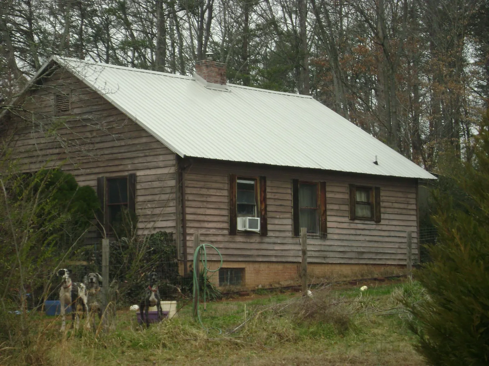 White metal roof on an old wood sided farmhouse, from a Metal Roof Installation job in Banner Elk